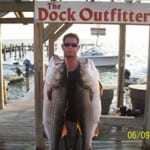 Man holding two large fish at The Dock Outfitter.