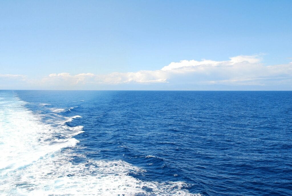 Vast blue ocean under a clear sky with gentle waves.