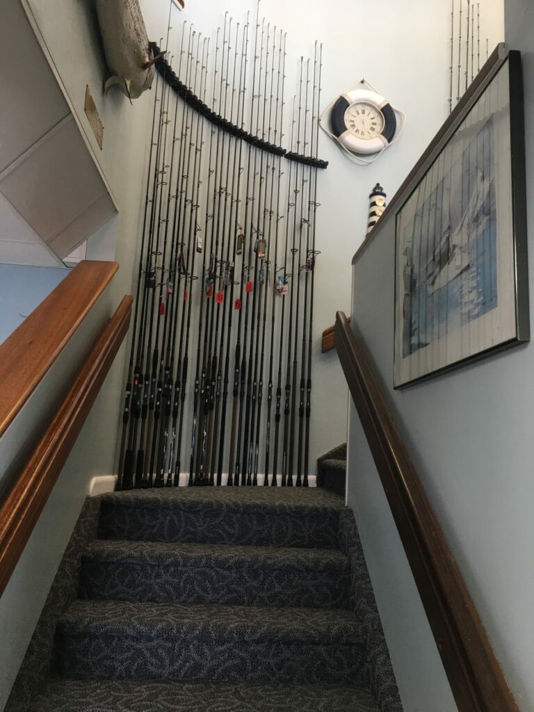 Decorative bead curtain hanging at the top of a carpeted staircase.