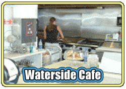 Busy kitchen scene at Waterside Cafe with a cook preparing food.