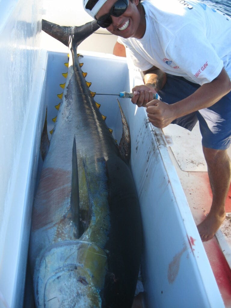 A man taking a picture with a huge fish on the storage