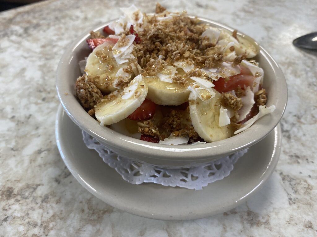 A bowl of oatmeal topped with banana slices, walnuts, and cinnamon.