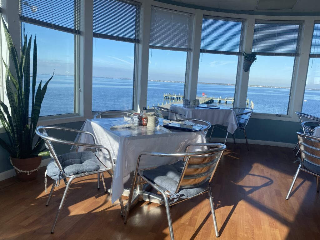 Cozy dining area with ocean views through large windows.