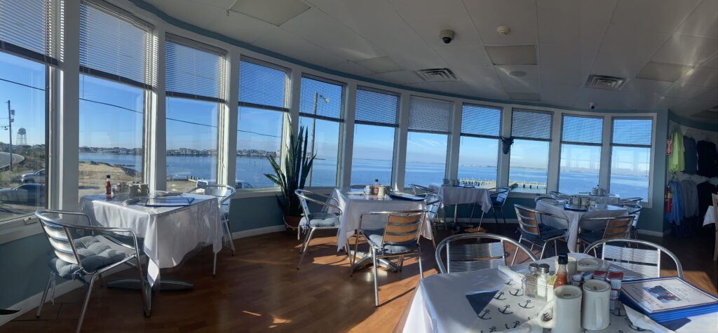 Elegant dining area with panoramic ocean views through large windows.